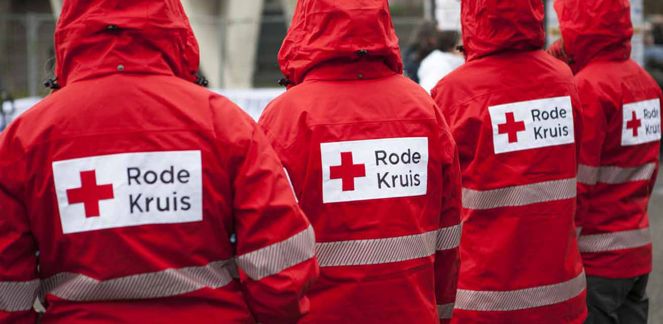 The team of the Dutch Red Cross in red jackets from the back