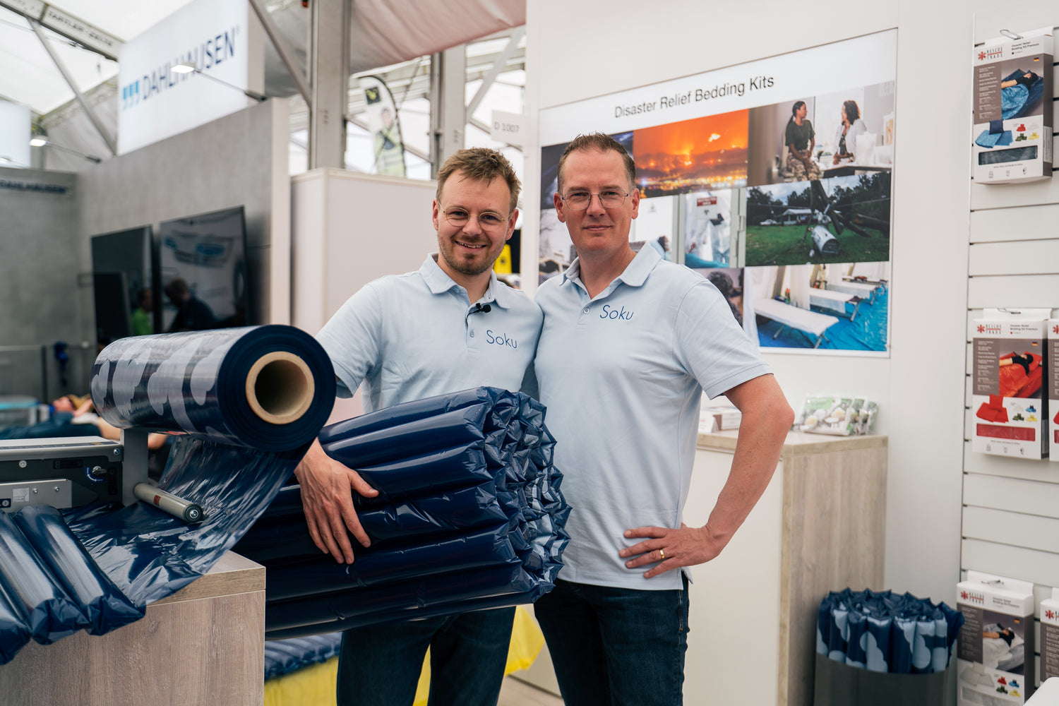 Sam and Gerard on a trade fair booth holding a Soku Minute Mattress