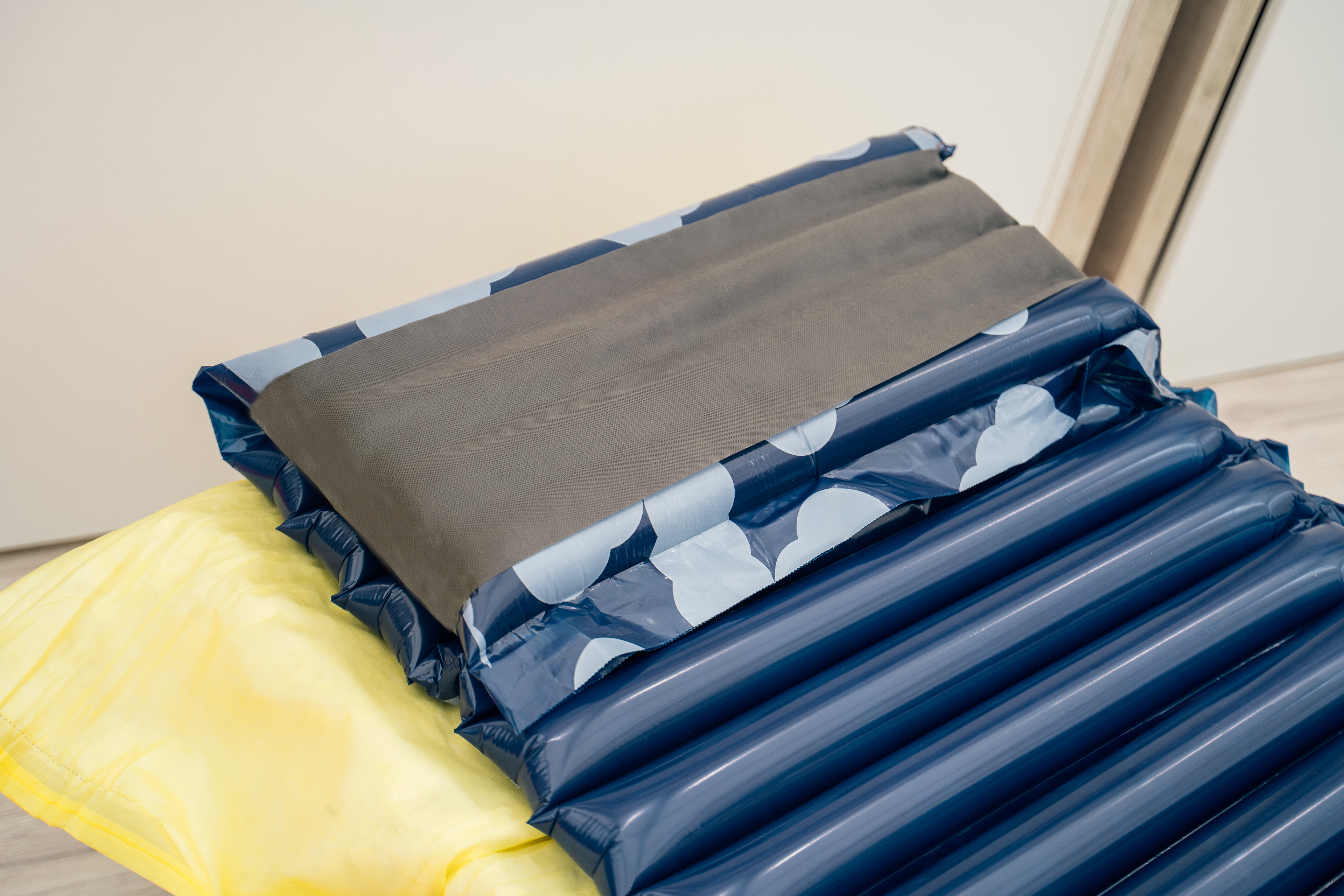 Inflatable air mattress with an integrated pillow on a light background