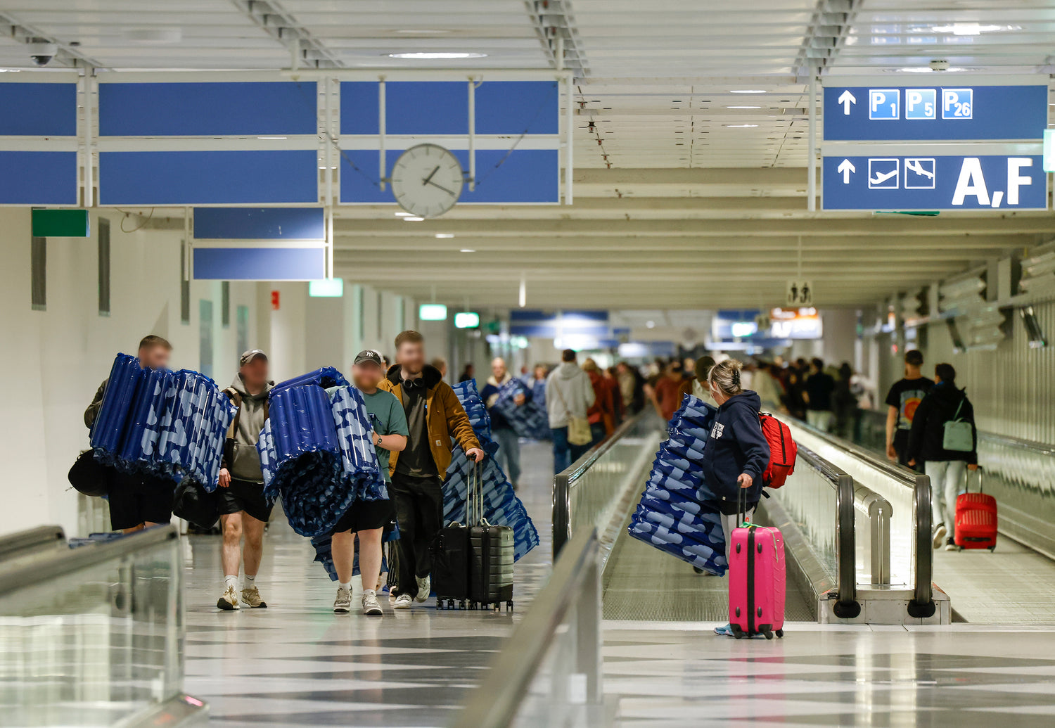 People with Soku Minute Mattress walking in Munich Airport terminal hall