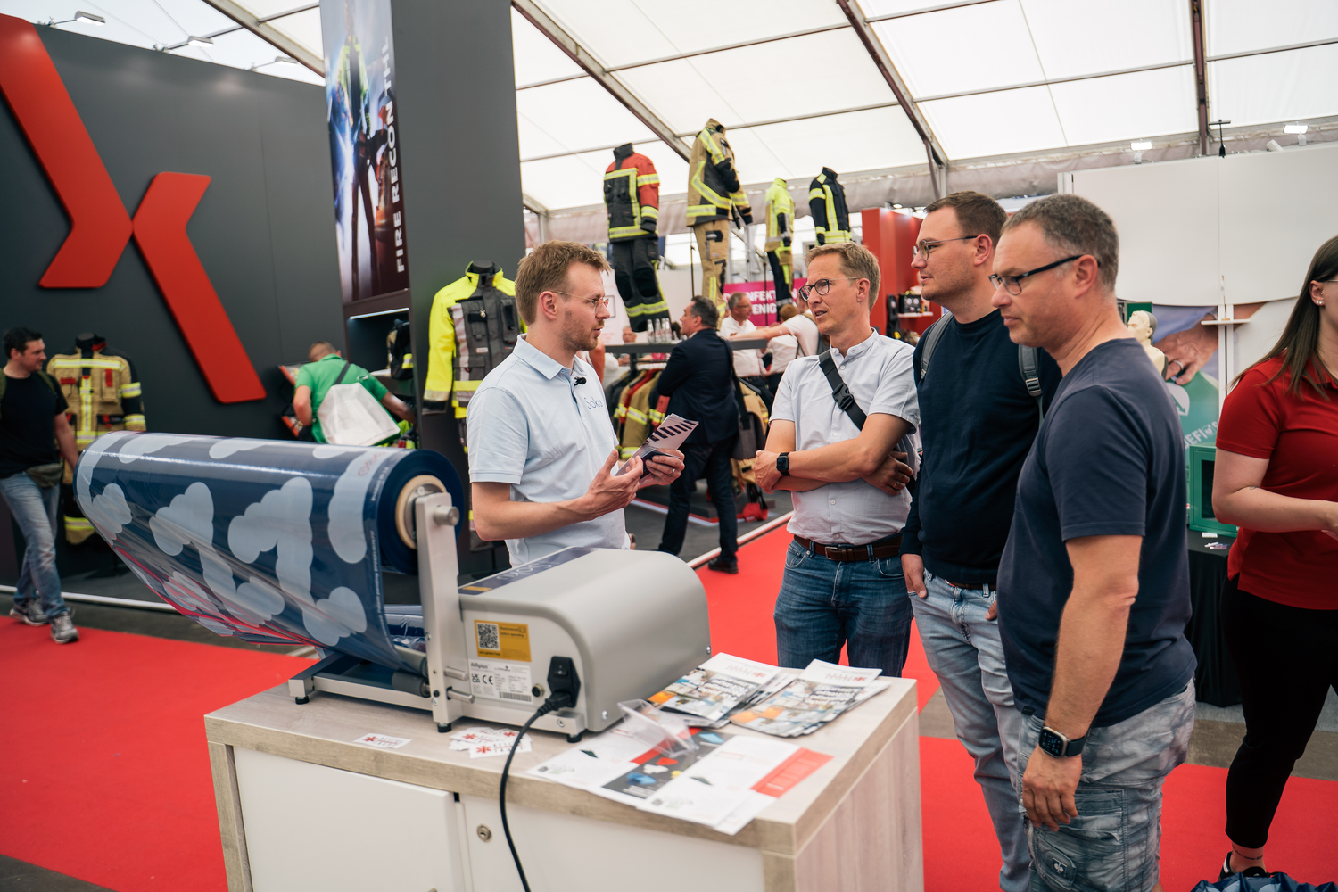 People interacting with a AIRplus Inflator machine at an exhibition stand from Soku